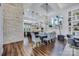 Open-concept dining area with high ceilings, a brick wall, and hardwood floors at 109 Twiggs Ln, Mooresville, NC 28117