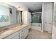 Bright bathroom with double sinks, granite counters, and stylish tile flooring, plus a tiled shower with glass door at 126 Fleming Dr, Statesville, NC 28677