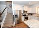 Modern kitchen with stainless steel appliances, granite counters, and stairs to the second floor at 126 Fleming Dr, Statesville, NC 28677