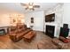 Comfortable living room with wood floors, leather seating, and a fireplace at 126 Fleming Dr, Statesville, NC 28677