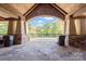 Spacious covered stone patio with stone archway overlooking treeline and partial view of a pool at 3067 Trace Meadow Ct, York, SC 29745