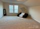 Spacious living room with a plush sofa, a decorative mirror, and a large window for ample natural light at 129 Johnson Manor St, Mooresville, NC 28115