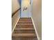 Carpeted staircase leading upstairs with white trim and a decorative wall hanging adds a cozy, personal touch at 129 Johnson Manor St, Mooresville, NC 28115
