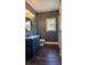 Stylish bathroom, featuring a dark blue vanity, marble shower, and dark wood-look flooring at 1703 Polk St, Monroe, NC 28110