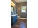 Contemporary bathroom with dark blue vanity, modern fixtures, and dark wood-look flooring at 1703 Polk St, Monroe, NC 28110