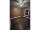 Bright bedroom with dark brown walls, ceiling fan, and dark laminate flooring at 1703 Polk St, Monroe, NC 28110