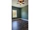 Serene bedroom with sage green walls, ceiling fan, and dark laminate flooring at 1703 Polk St, Monroe, NC 28110