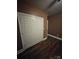 Well-lit bedroom with double door closet, dark laminate floors and brown walls at 1703 Polk St, Monroe, NC 28110