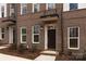 Brick townhome with dark brown door and landscaping at 2208 Noble Townes Way, Charlotte, NC 28262