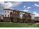 Brown brick townhouses with white accents, and a grassy lawn at 2208 Noble Townes Way, Charlotte, NC 28262