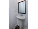 Small powder room with pedestal sink and mirror at 2208 Noble Townes Way, Charlotte, NC 28262