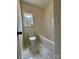 This bathroom features a toilet, bathtub, and marble floors, illuminated by a window with a peaceful view at 315 Bonaventure Dr, Salisbury, NC 28147