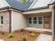 Charming front entrance featuring a wood door, complemented by three windows and brick and vinyl siding accents at 315 Bonaventure Dr, Salisbury, NC 28147