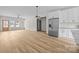 Bright living room featuring wood-look floors and a view of the kitchen with stainless appliances and white cabinets at 315 Bonaventure Dr, Salisbury, NC 28147