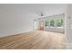Spacious and bright living area featuring wood-look floors and a view to a wooden exterior door and trees at 315 Bonaventure Dr, Salisbury, NC 28147