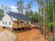 Rear view of a home with a wooden deck, surrounded by trees and construction equipment, highlighting outdoor space at 315 Bonaventure Dr, Salisbury, NC 28147