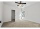Bright bedroom featuring neutral carpet, ceiling fan, and a closet for ample storage space at 606 Meadow Ave, Spencer, NC 28159
