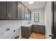 Bright laundry room with stylish dark gray cabinets and white subway tile at 705 Mcalway Rd, Charlotte, NC 28211