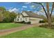 Side view of a white brick home showcasing a two-car garage and driveway at 116 Jim Parker Rd, Wesley Chapel, NC 28110