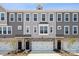 Three-unit townhome building with gray siding, brick accents, and two-car garages at 4375 Reed Creek Dr, Sherrills Ford, NC 28673