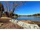 Peaceful lakeside path with rock retaining wall and mature trees at 4375 Reed Creek Dr, Sherrills Ford, NC 28673