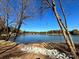 Lakefront property with rocky shoreline and mature trees under a clear sky at 4375 Reed Creek Dr, Sherrills Ford, NC 28673