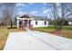 Newly built home with red and white siding, a covered porch, and a concrete driveway at 1244 Bob Falls Rd, Shelby, NC 28150