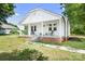 Quaint white home featuring a covered front porch with seating and a brick foundation at 2401 Boy Scout Rd, Lincolnton, NC 28092