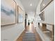 Bright hallway with wood floors, modern art, mirrors, and a view into the living room with natural light at 2561 Blue Sky Meadows Dr, Monroe, NC 28110