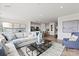 Well-lit living room with hardwood floors, open to a modern kitchen with stainless steel appliances at 2561 Blue Sky Meadows Dr, Monroe, NC 28110