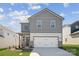 Charming two-story home with gray siding, brick accents, and an attached two-car garage at 2565 Blue Sky Meadows Dr, Monroe, NC 28110