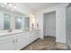 Spacious bathroom featuring a dual sink vanity with quartz countertops and elegant herringbone tile flooring at 3029 Quinebaug Rd, Fort Mill, SC 29715