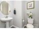 Cozy powder room featuring a pedestal sink, toilet, and tasteful decor, ideal for guests at 3029 Quinebaug Rd, Fort Mill, SC 29715