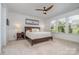 Bright primary bedroom with large windows, ceiling fan, and plush carpet flooring providing ample natural light at 3029 Quinebaug Rd, Fort Mill, SC 29715