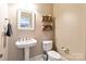 Elegant bathroom with a pedestal sink, toilet, and decorative shelving at 4815 Sugar And Wine Rd, Monroe, NC 28110