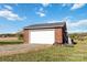 Brick detached garage with a white door and gravel driveway at 4815 Sugar And Wine Rd, Monroe, NC 28110