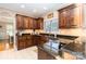 Kitchen features dark wood cabinets, granite countertops, and a view into the dining area at 4815 Sugar And Wine Rd, Monroe, NC 28110