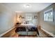 Inviting bedroom featuring wood-look floors, neutral colors, and ample natural light from the window at 9542 Riviera Dr, Sherrills Ford, NC 28673