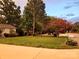 Landscaped front yard with mature trees, flowering bushes, and a well-maintained lawn at 9542 Riviera Dr, Sherrills Ford, NC 28673