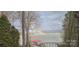 Scenic lake view featuring a rainbow, pier, and boat dock, enhanced by lush trees at 9542 Riviera Dr, Sherrills Ford, NC 28673