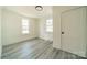 Bright bedroom with wood-look floors and two windows at 119 Nat Barber Ave, Gastonia, NC 28052