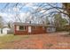 Charming single-story brick home with a white door and mature trees in the front yard at 2209 Dale Ave, Lincolnton, NC 28092