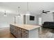 Open-concept living room features an island with barstool seating, pendant lights, and hardwood floors at 25622 Seagull Dr # 645, Lancaster, SC 29720