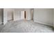 An empty bedroom with plush carpeting and multiple doors offers versatility to be used as a guest or Gathering room at 4919 Polo Gate Blvd, Charlotte, NC 28216