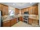 Kitchen with stainless steel appliances, tiled backsplash, and abundant wood cabinetry at 4919 Polo Gate Blvd, Charlotte, NC 28216