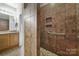 Tiled walk-in shower with a built-in shower caddy and grab bar offers accessible comfort with upscale features at 4919 Polo Gate Blvd, Charlotte, NC 28216