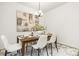 Bright dining room features a wood table, white chairs, and modern art at 8001 Willhill Rd, Charlotte, NC 28227