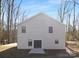 Rear view of gray house, showcasing a patio and wooded setting at 8001 Willhill Rd, Charlotte, NC 28227