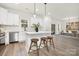 Modern kitchen with white cabinets, marble backsplash and island with seating at 8001 Willhill Rd, Charlotte, NC 28227