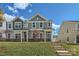 Two-story townhome with green siding, brick accents, and a landscaped lawn at 9744 Inkberry Dr, Gastonia, NC 28056